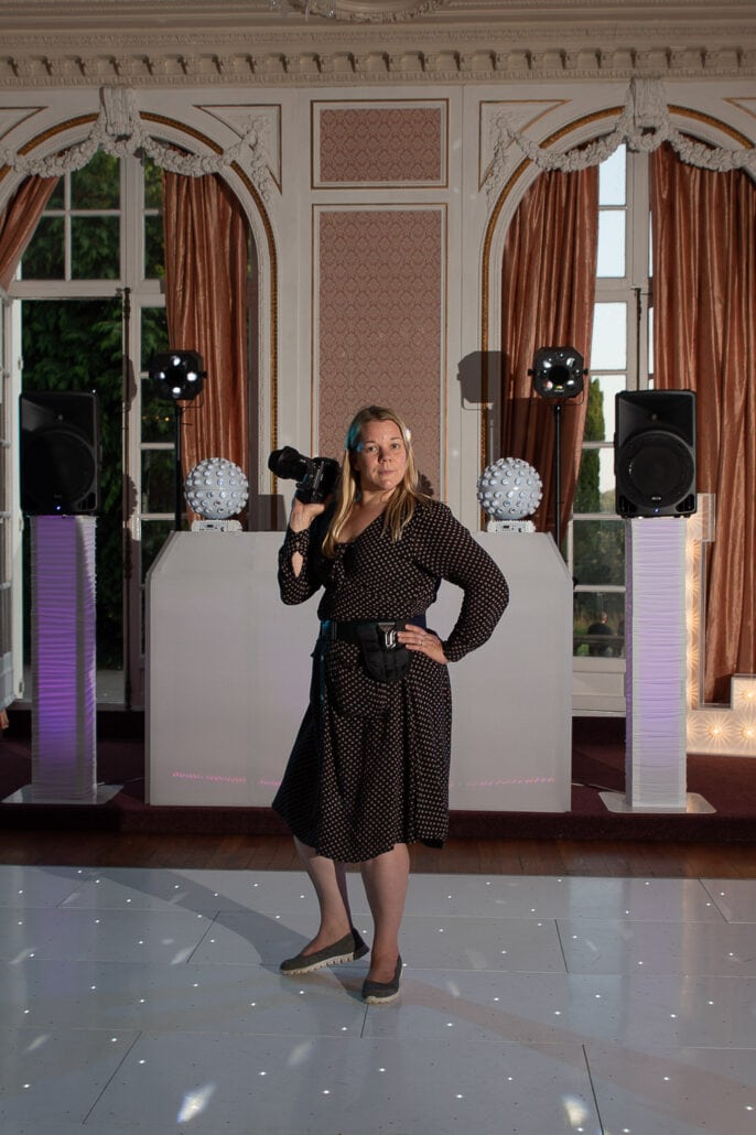 A south wales wedding photographer capturing a woman standing on a stage with a camera.