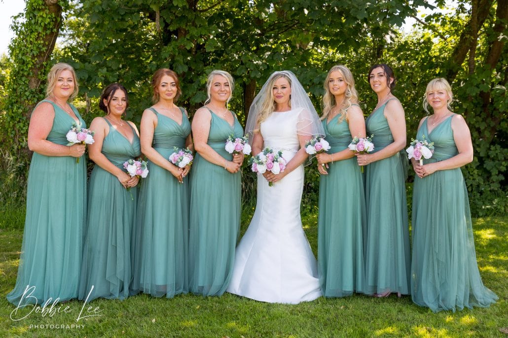 A bride and her bridesmaids pose for a photo.