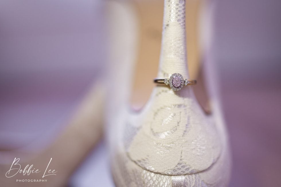 A close up of a wedding ring on a white shoe.