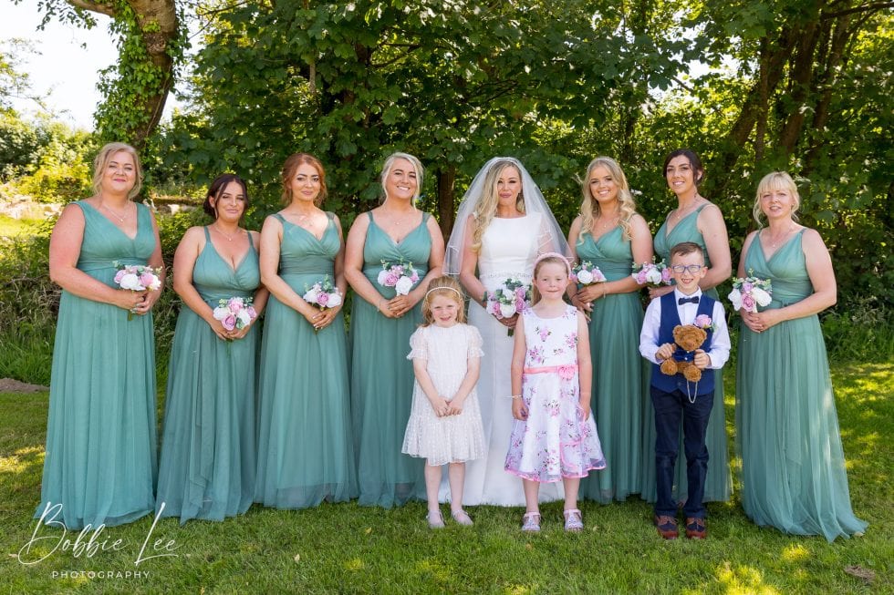 The bride and bridesmaids are posing for a picture.