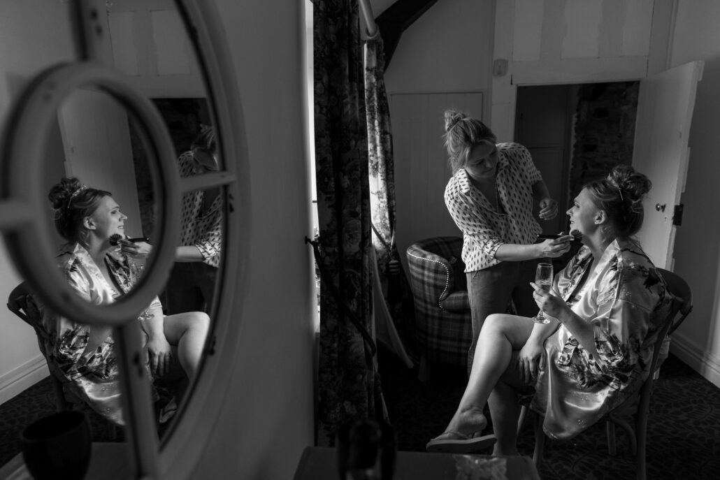 A bride preparing in front of a mirror captured by a South Wales wedding photographer.