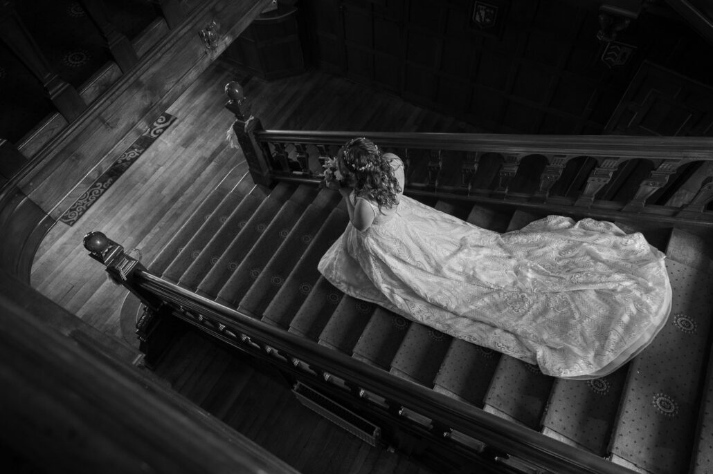 A south Wales wedding photographer captures a woman in a white dress lying down on a staircase.