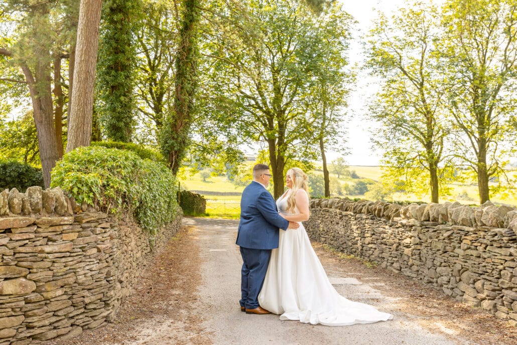 A bride and groom photographed on a stone path in the countryside by a South Wales wedding photographer.