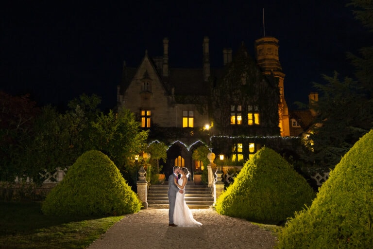 A wedding photographer capturing a bride and groom at a South Wales castle at night.