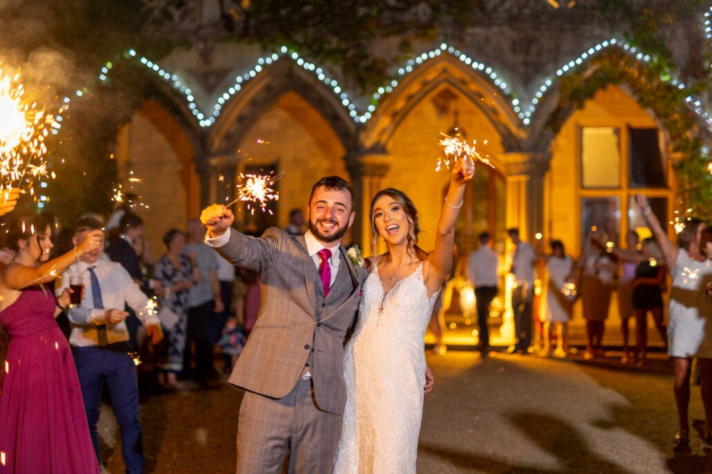 A bride and groom holding sparklers at their wedding reception captured by a South Wales wedding photographer.