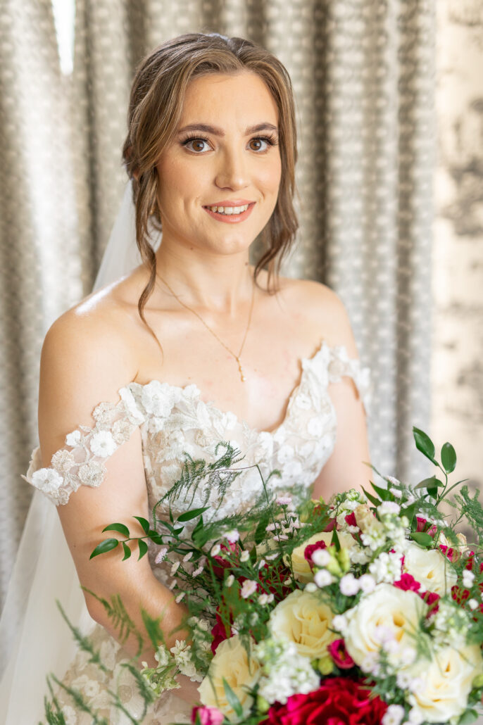 A bride in a wedding dress holding a bouquet.