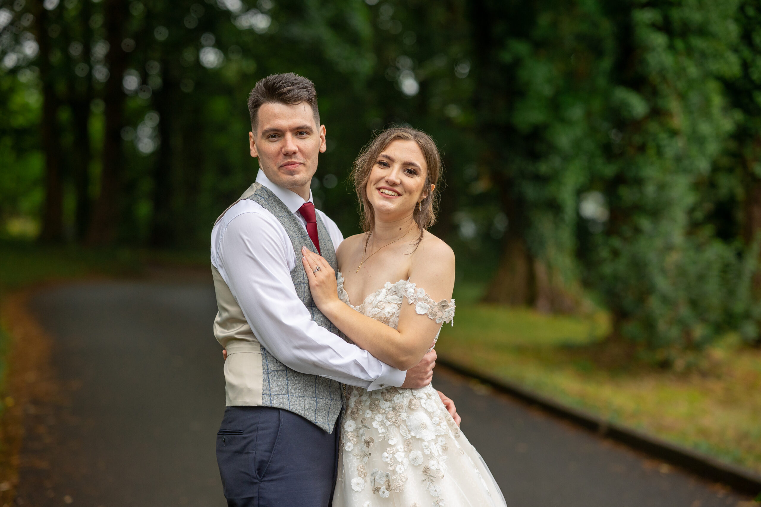 A South Wales wedding photographer captures a bride and groom posing in the woods.