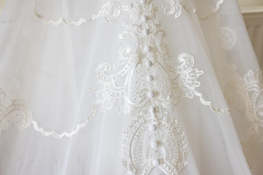A close up of a white wedding dress.