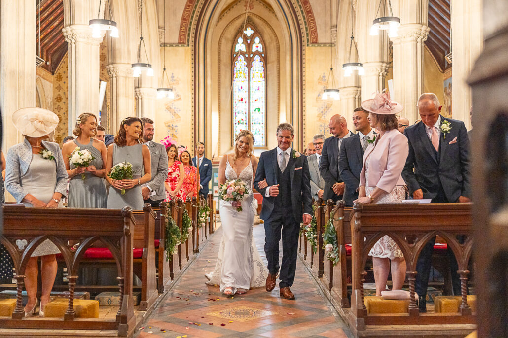 A bride and groom walking down the aisle of a church.