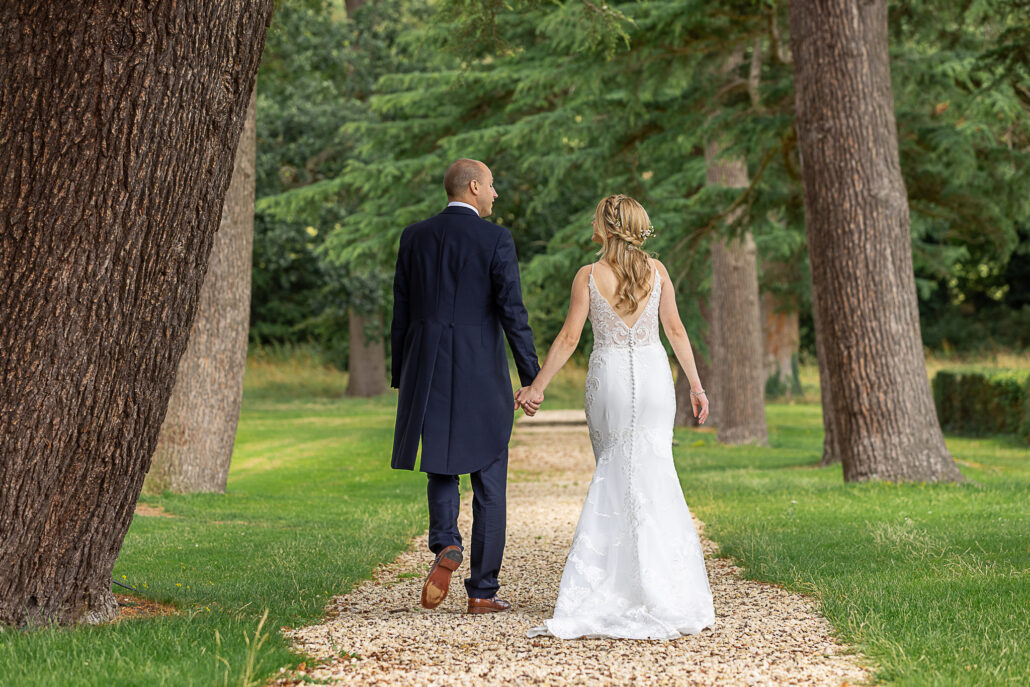 A bride and groom walking down a path.
