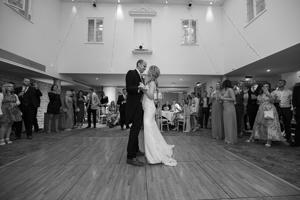 A black and white photo of a bride and groom sharing their first dance.