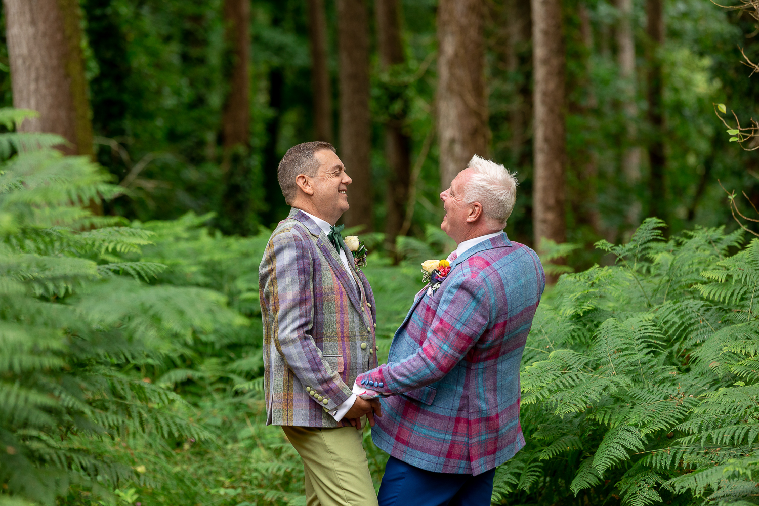 South Wales wedding photographer capturing two men standing in the woods, holding hands.