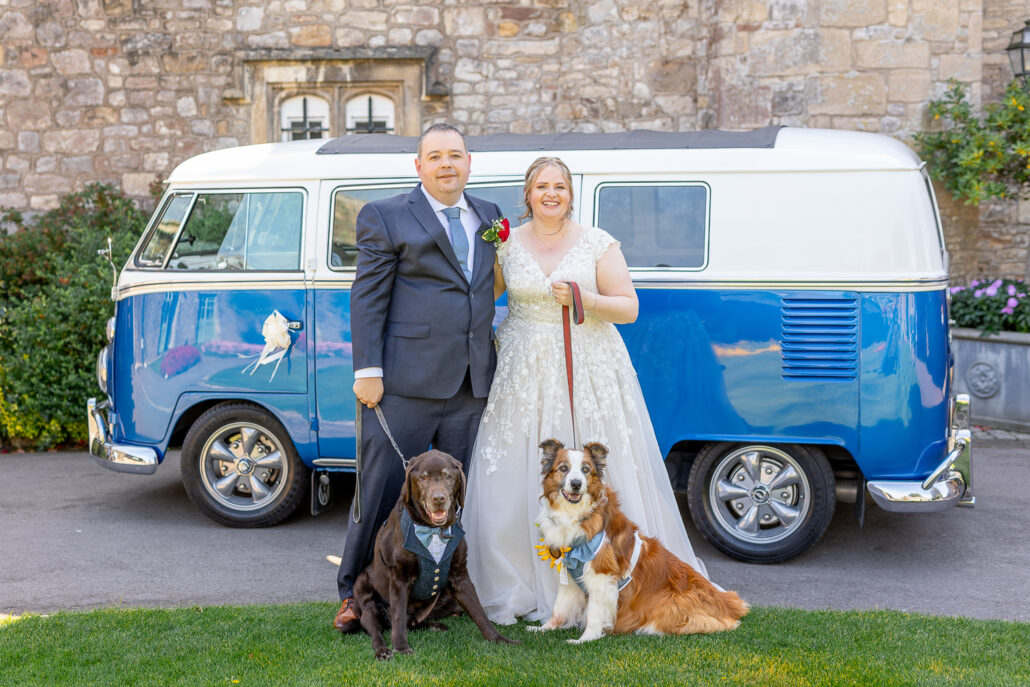 A bride and groom standing in front of a blue vw bus.