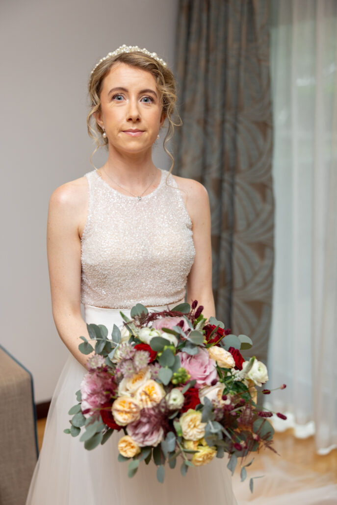 A bride in a wedding dress holding a bouquet.