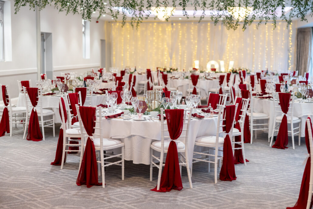 A room with red and white tables and chairs.