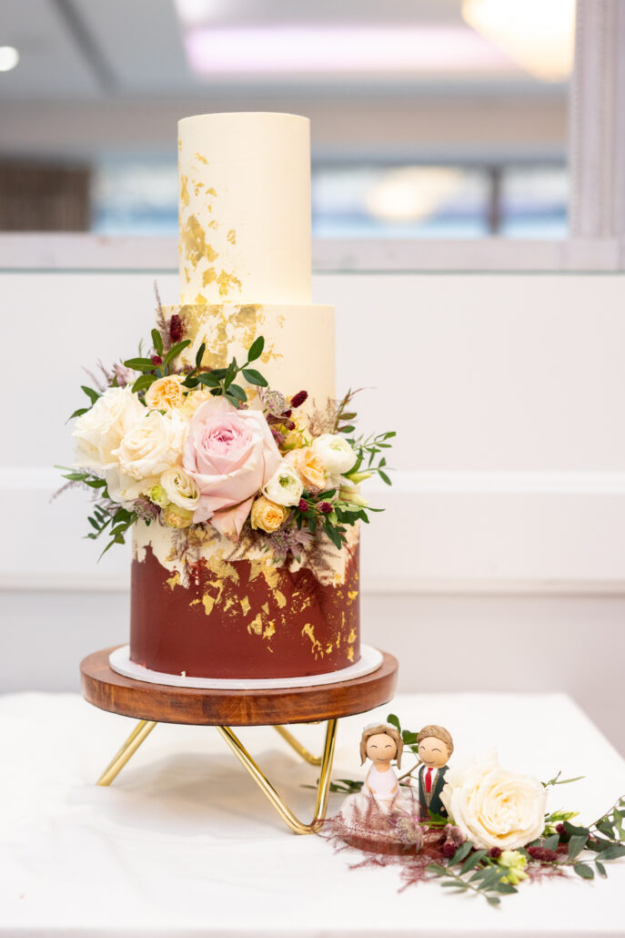 A wedding cake with flowers on top.